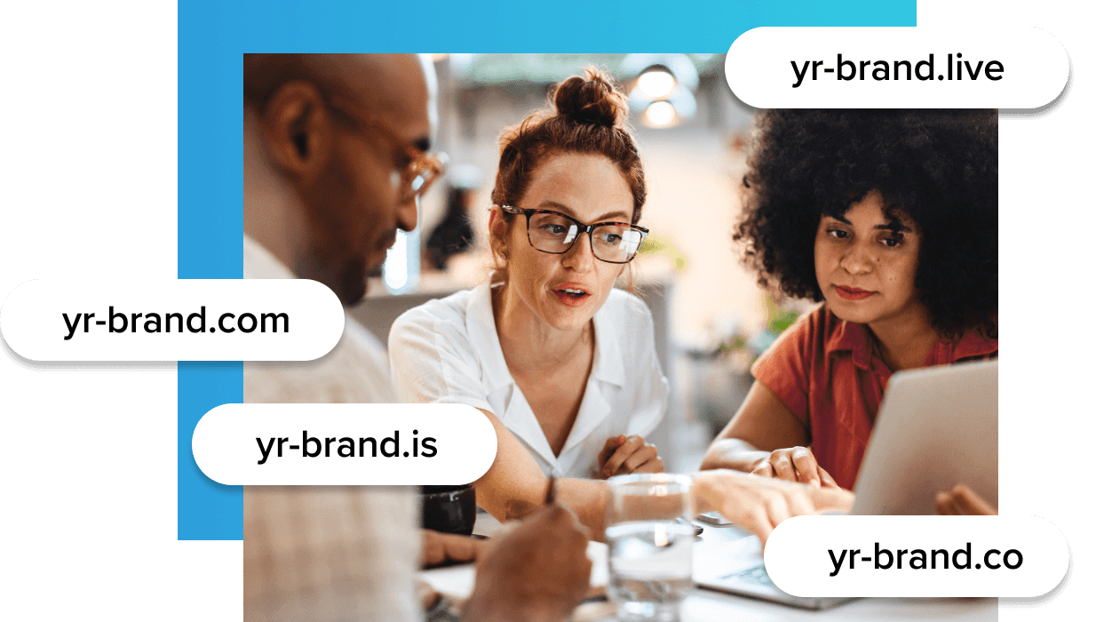 Three people huddled together at a desk and looking at a laptop that one person is pointing at and four pop-up bubbles overlaid against the photo showing different domains such as yr-brand.live, yr-brand.com, yr-brand.is, and yr-brand.co.